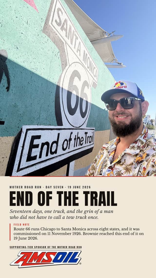 Designed sheet, End Of The Trail: Solomon grinning beside the painted Santa Monica End of the Trail sign on the pier wall, day seven.